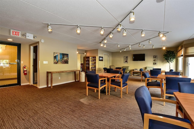 carpeted dining area with a textured ceiling