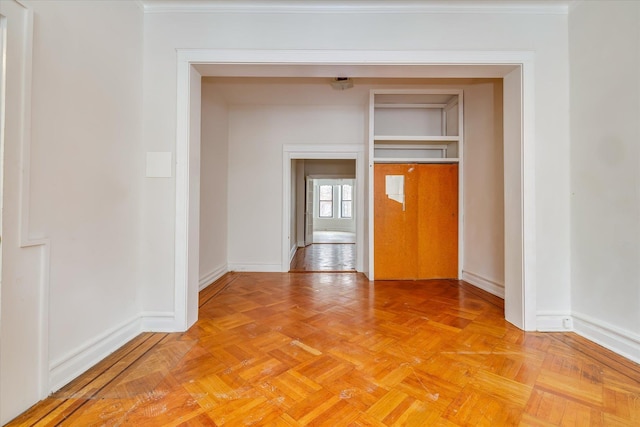 spare room with light parquet floors and crown molding