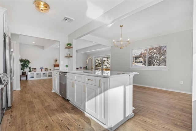 kitchen featuring dishwasher, white cabinetry, sink, hanging light fixtures, and a center island with sink