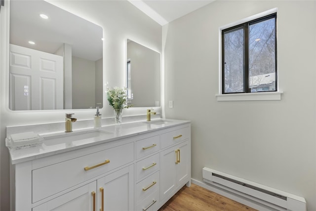 bathroom featuring vanity, hardwood / wood-style floors, and a baseboard radiator