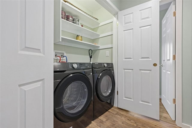 clothes washing area featuring light wood-type flooring and washing machine and clothes dryer