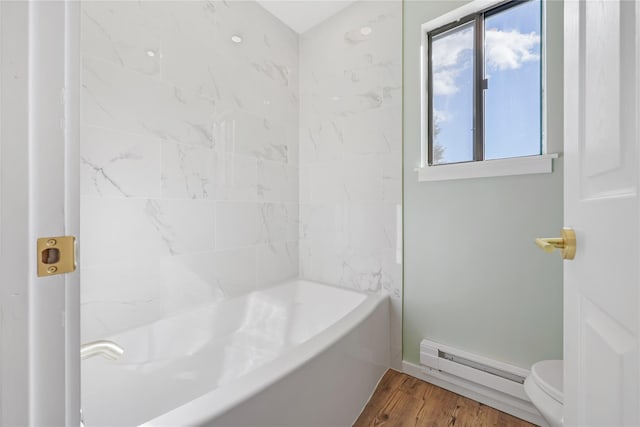 bathroom with hardwood / wood-style flooring, toilet, a baseboard heating unit, and washtub / shower combination