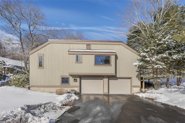 exterior space featuring aphalt driveway and an attached garage