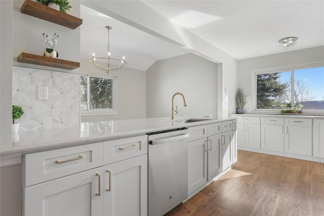 kitchen with open shelves, a sink, light countertops, tasteful backsplash, and stainless steel dishwasher