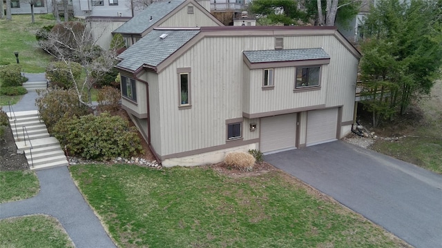 view of front facade with a garage, a front lawn, aphalt driveway, roof with shingles, and stairway