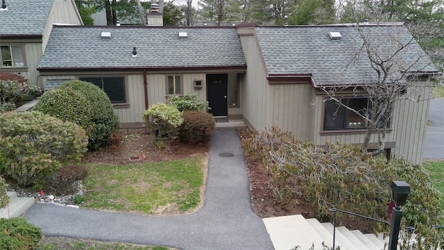 view of front of home with roof with shingles and a chimney