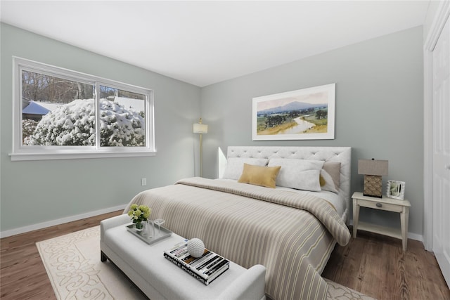 bedroom with baseboards and wood finished floors