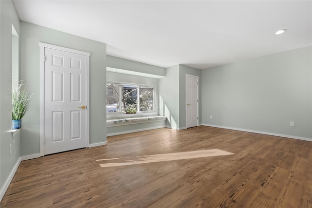 unfurnished living room featuring baseboards, recessed lighting, and wood finished floors