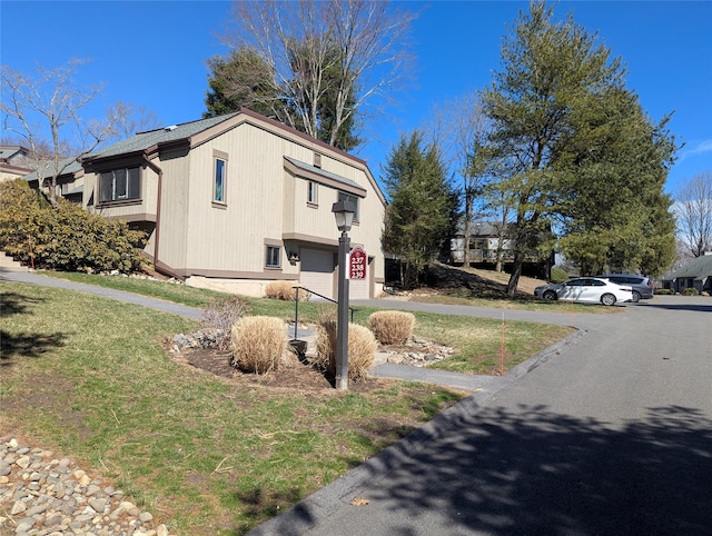 view of side of property with an attached garage and a yard