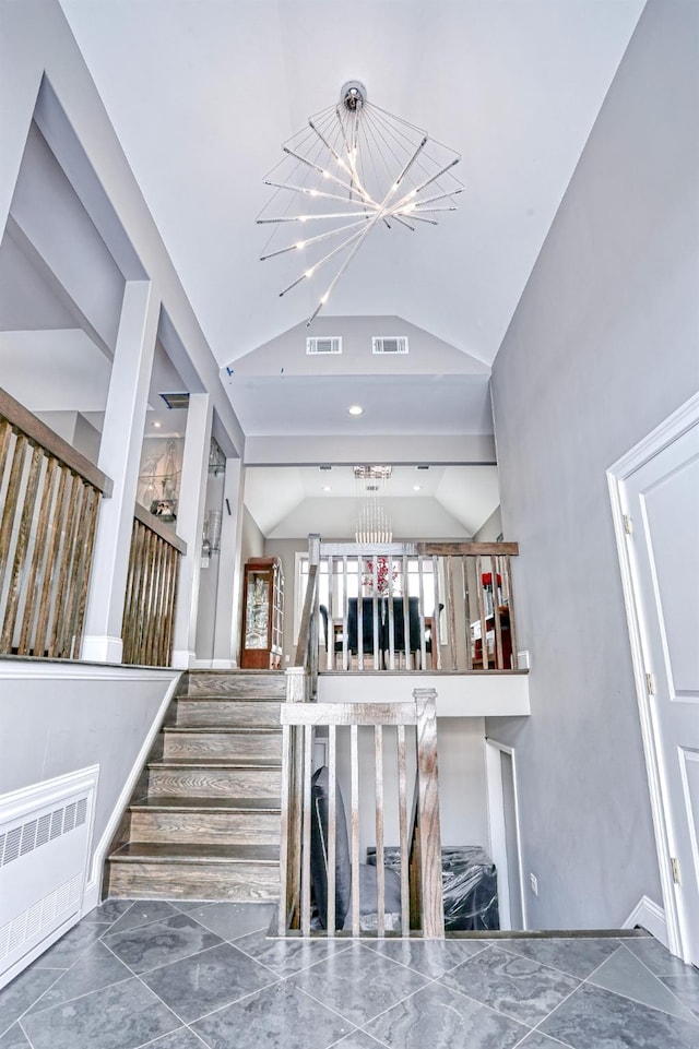 interior space featuring a notable chandelier, vaulted ceiling, and radiator heating unit