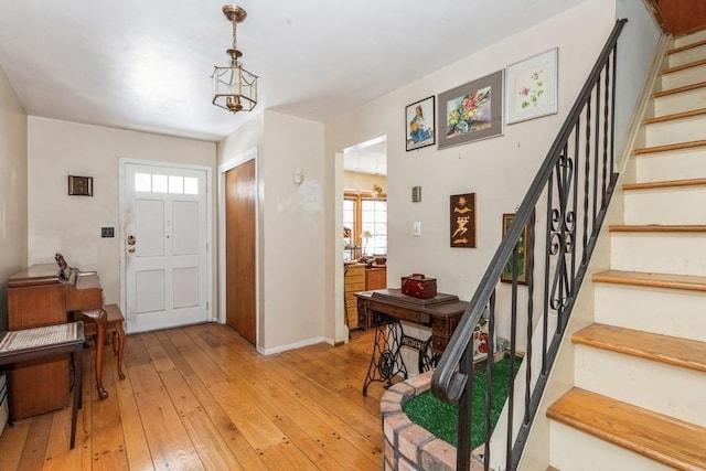 entrance foyer with light wood-type flooring and an inviting chandelier