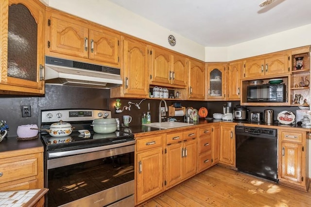 kitchen with sink, light hardwood / wood-style floors, backsplash, and black appliances