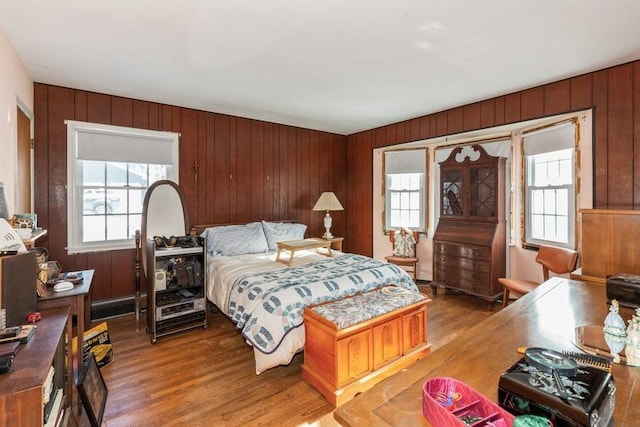 bedroom with wood walls and hardwood / wood-style flooring