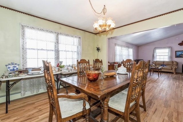 dining room featuring vaulted ceiling, light hardwood / wood-style flooring, and a notable chandelier