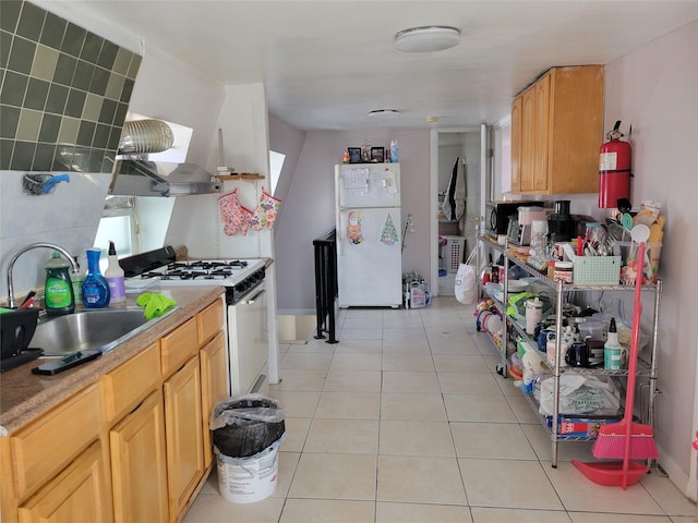 kitchen with white appliances, light countertops, a sink, and light tile patterned flooring