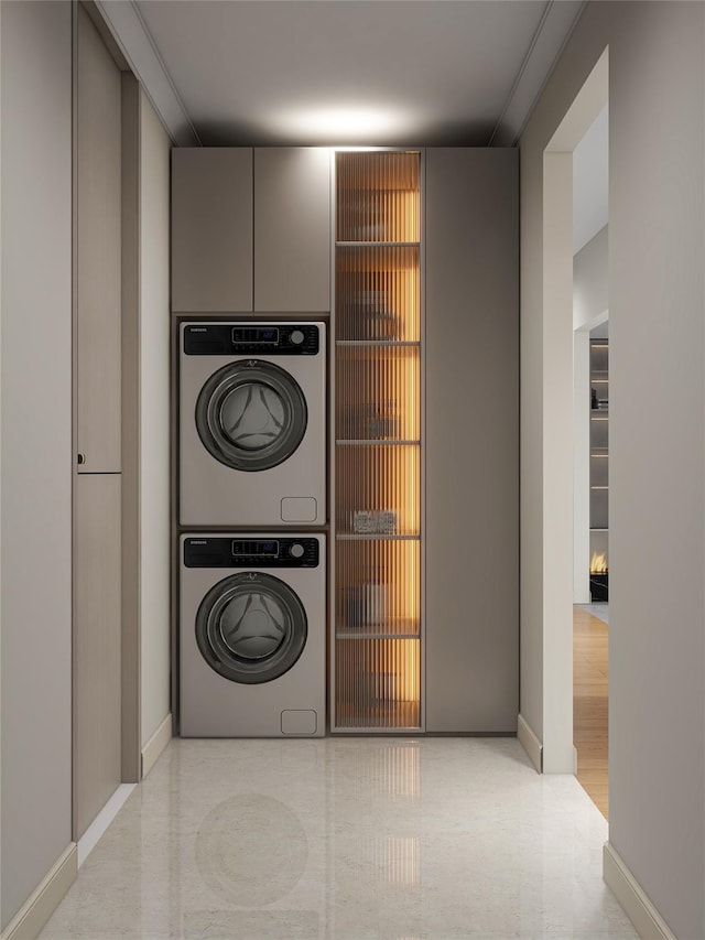 laundry area featuring baseboards and stacked washing maching and dryer