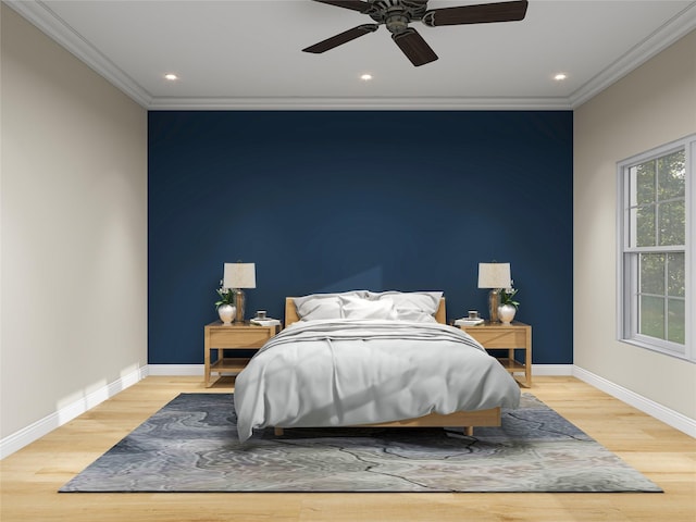 bedroom featuring an accent wall, ornamental molding, light wood-style floors, and baseboards