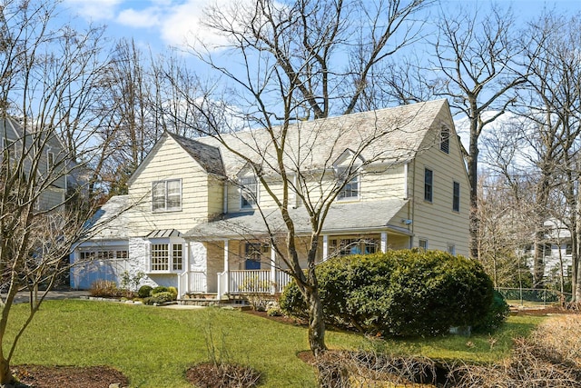 view of front of home with a garage, a porch, and a front yard