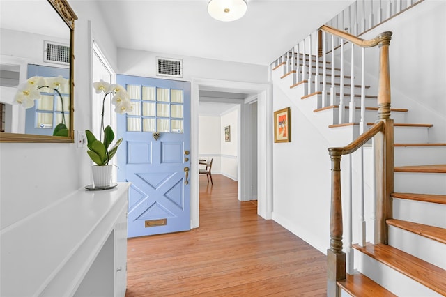 foyer featuring visible vents, stairway, and light wood-type flooring