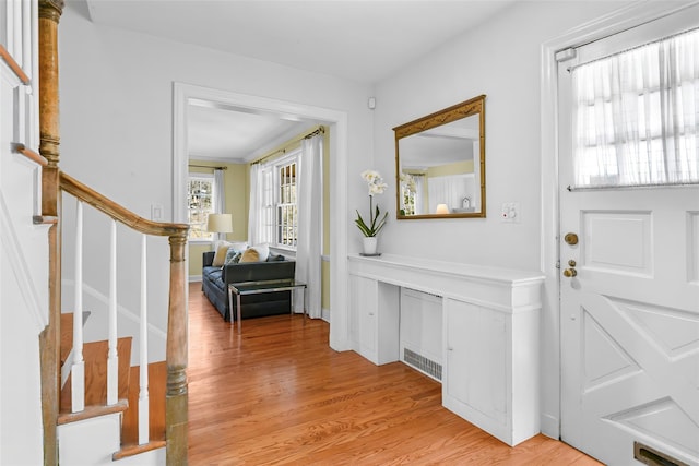 foyer featuring light wood-style floors and stairs