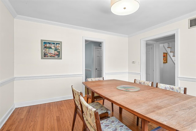 dining space with stairs, baseboards, crown molding, and light wood finished floors