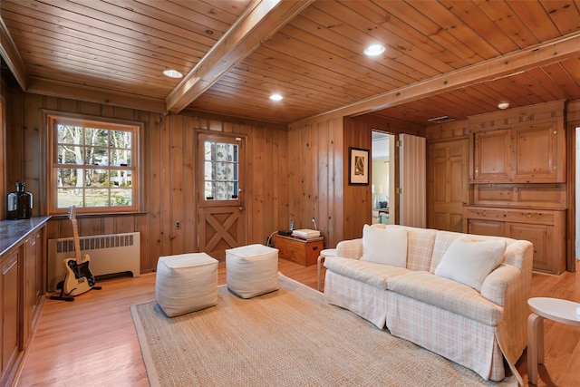 living area featuring radiator, beamed ceiling, wood walls, wood ceiling, and light wood-type flooring