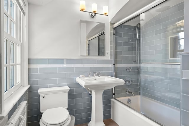 bathroom with tile walls, toilet, and shower / bathing tub combination