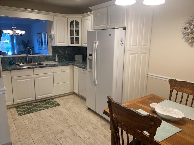 kitchen with backsplash, sink, white appliances, and white cabinets