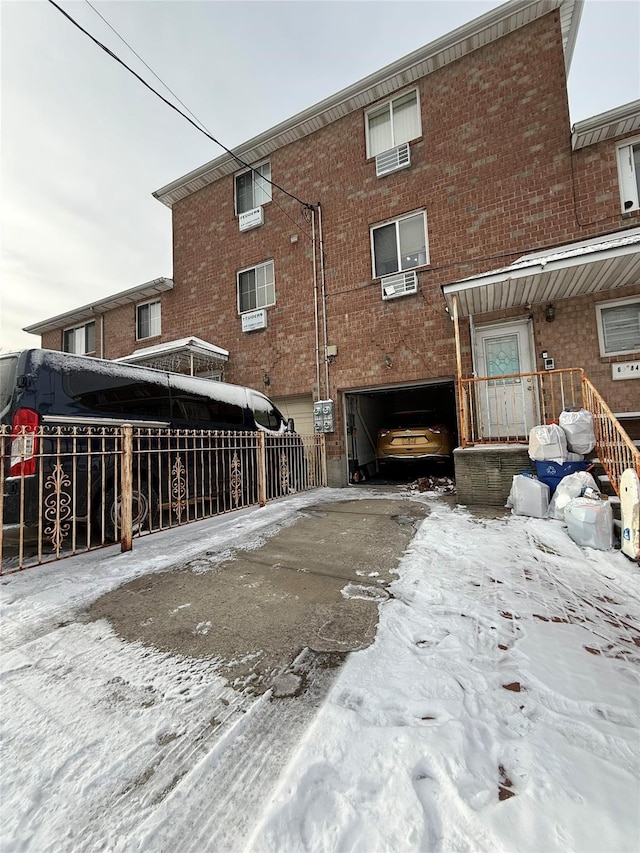 view of snowy exterior featuring a garage