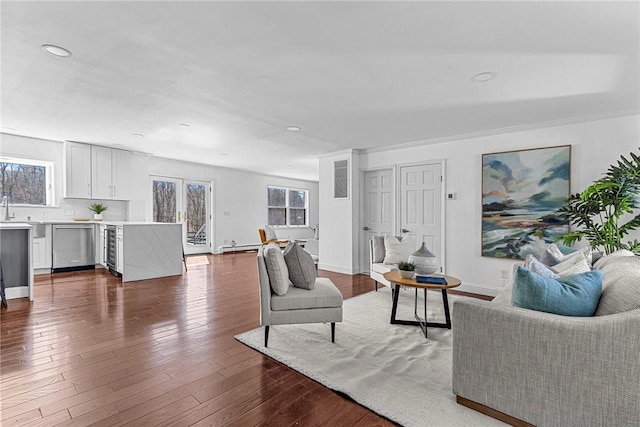 living room featuring crown molding, dark wood-type flooring, a wealth of natural light, and beverage cooler