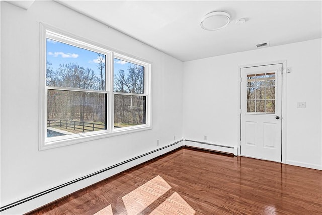 spare room featuring a baseboard radiator and hardwood / wood-style floors