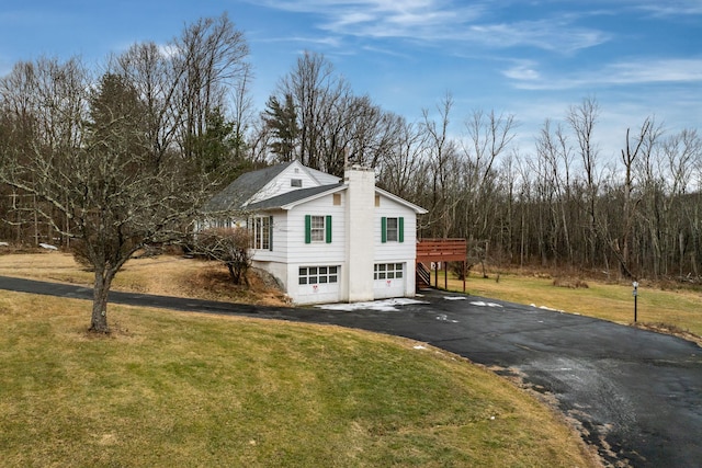 view of side of home featuring a lawn and a wooden deck