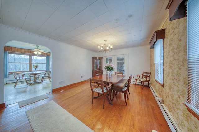 dining space featuring light hardwood / wood-style floors, a baseboard heating unit, ornamental molding, and an inviting chandelier