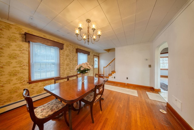 dining space featuring a notable chandelier, hardwood / wood-style flooring, a healthy amount of sunlight, and crown molding