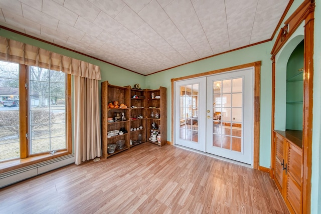 spare room featuring ornamental molding, a baseboard radiator, light hardwood / wood-style floors, and french doors