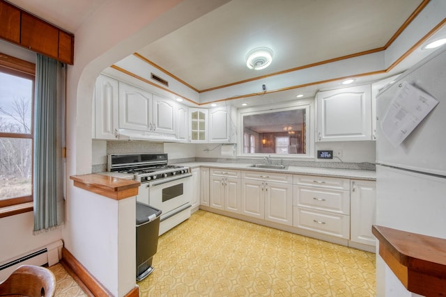 kitchen with a baseboard radiator, sink, white cabinetry, ornamental molding, and double oven range