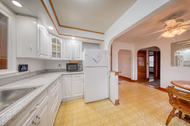 kitchen with white cabinets, ceiling fan, white refrigerator, and ornamental molding