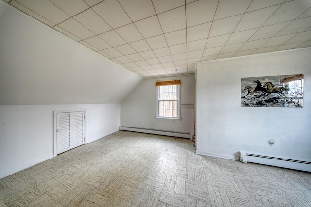 additional living space with a baseboard radiator and lofted ceiling