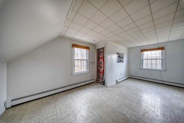 additional living space with a baseboard radiator, plenty of natural light, and vaulted ceiling