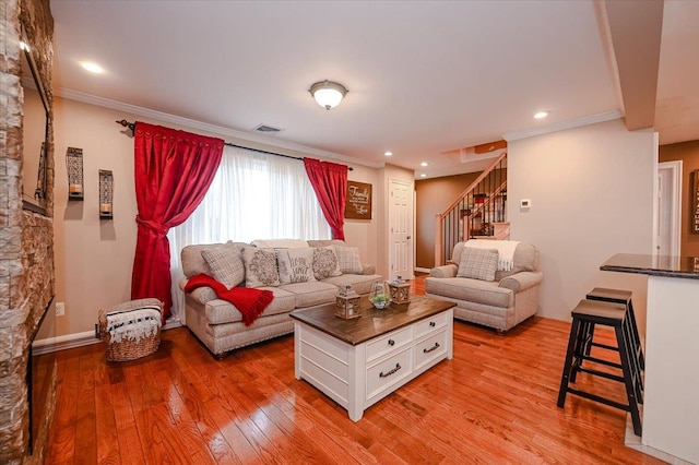 living room featuring crown molding and light hardwood / wood-style flooring