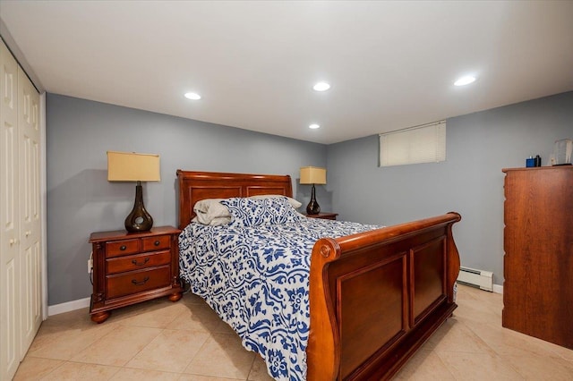 bedroom featuring a closet, light tile patterned floors, and a baseboard radiator