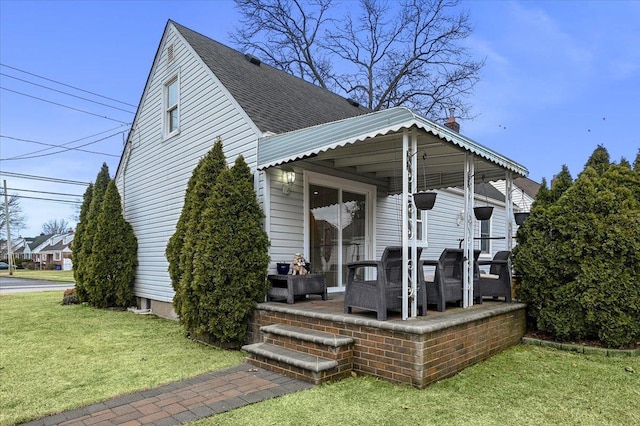 back of property featuring a lawn