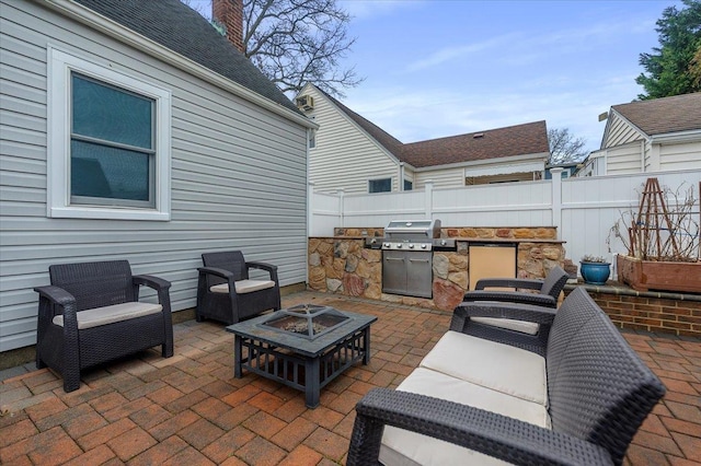 view of patio with grilling area, an outdoor kitchen, and a fire pit