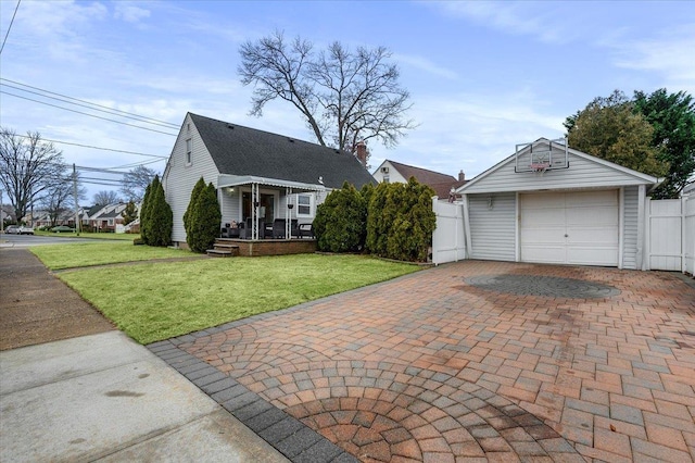 view of front facade featuring a garage, a front yard, and an outbuilding