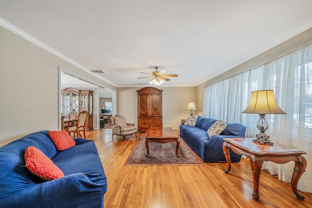 living room featuring crown molding, ceiling fan, and light hardwood / wood-style flooring