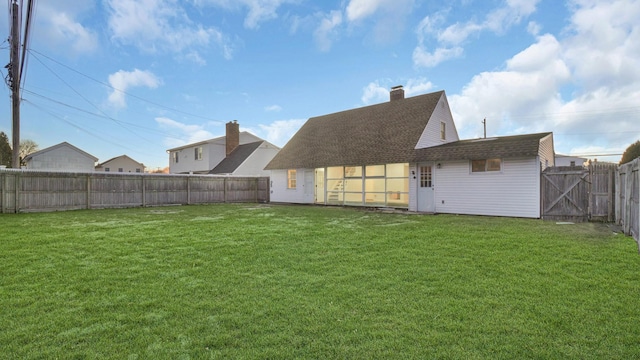 rear view of property featuring a lawn