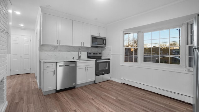 kitchen with white cabinetry, stainless steel appliances, decorative backsplash, and a baseboard heating unit