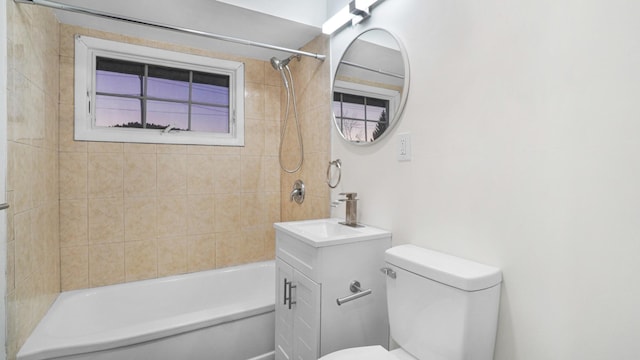 full bathroom featuring vanity, tiled shower / bath, and toilet