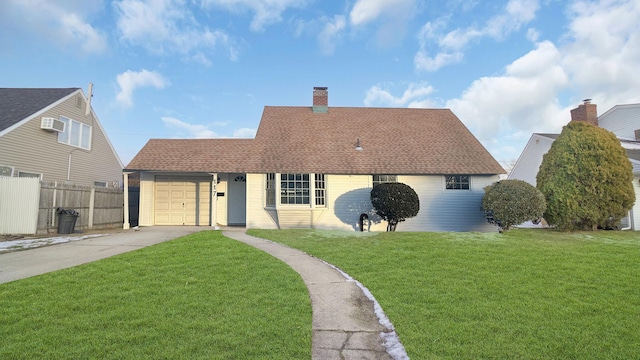 view of front of house with a shingled roof, concrete driveway, an attached garage, a front yard, and fence