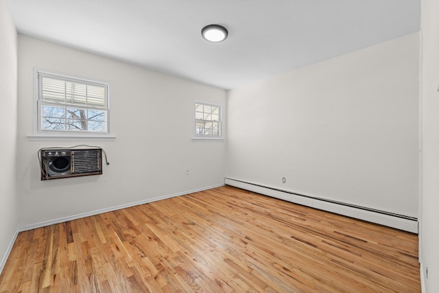 empty room featuring light wood-type flooring and baseboard heating